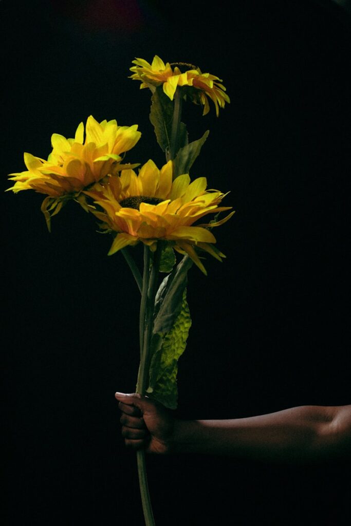 a person holding a bunch of yellow flowers